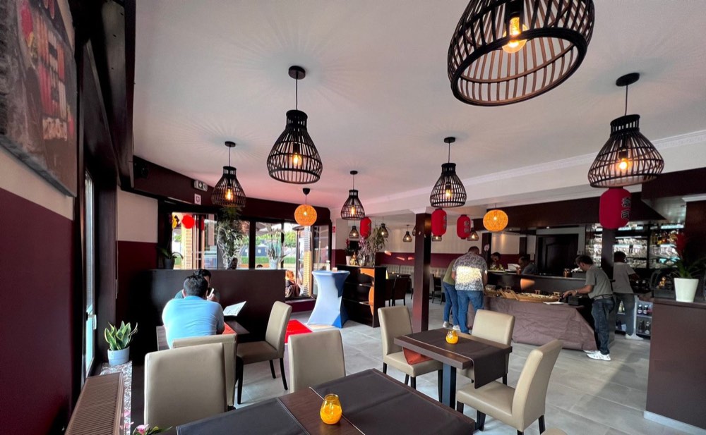 De eetzaal met rieten hanglampen en rode lampionnen
